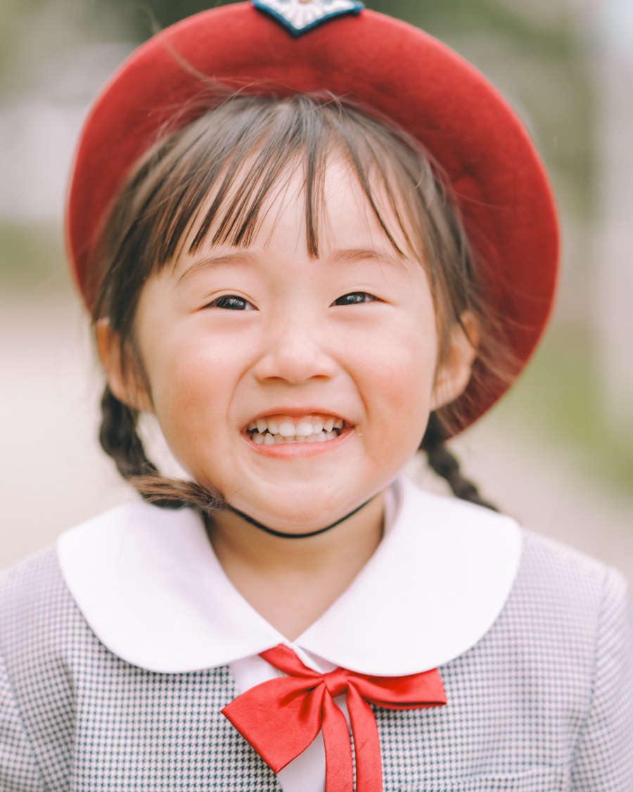 赤い帽子で笑う女の子